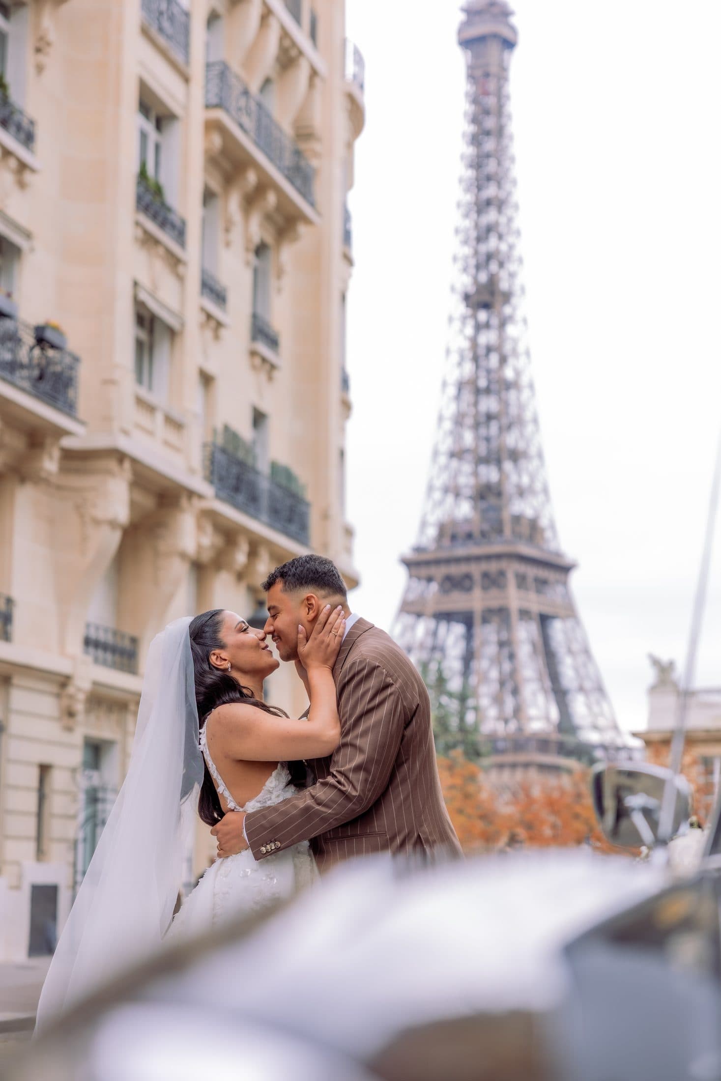 Mariés front contre front devant la Tour Eiffel dans une lumière d'automne