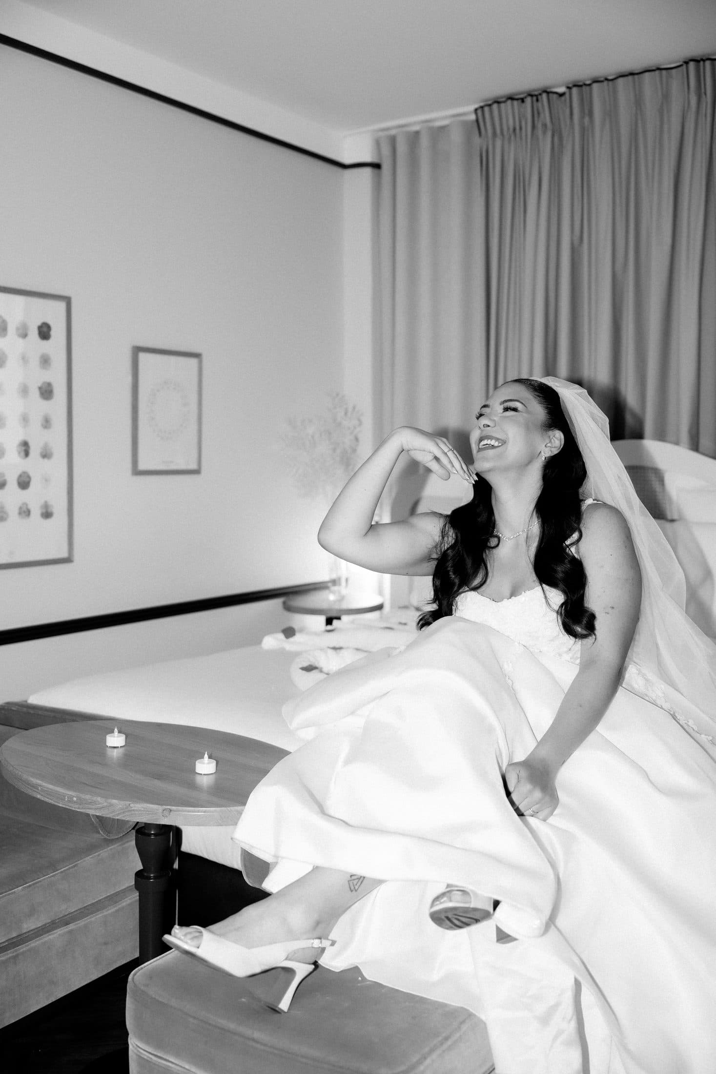 Mariée éclatant de rire pendant les préparatifs, photo en noir et blanc